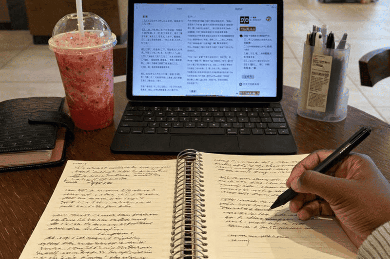 Checklist de caloura na faculdade: o que ninguém te conta 2 Imagem de mulher fazendo checklist de caloura na faculdade e anotações na cafeteria