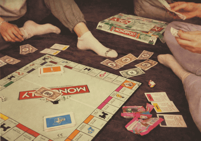 Coisas para fazer em casa com as amigas nas férias 3 Imagem de amigas jogando jogos de tabuleiro como uma das coisas para fazer em casa com as amigas nas férias