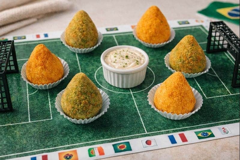Ideias de petiscos para assistir à Copa 2 petiscos para assistir à Copa com coxinhas organizadas em formato de campo de futebol temático
