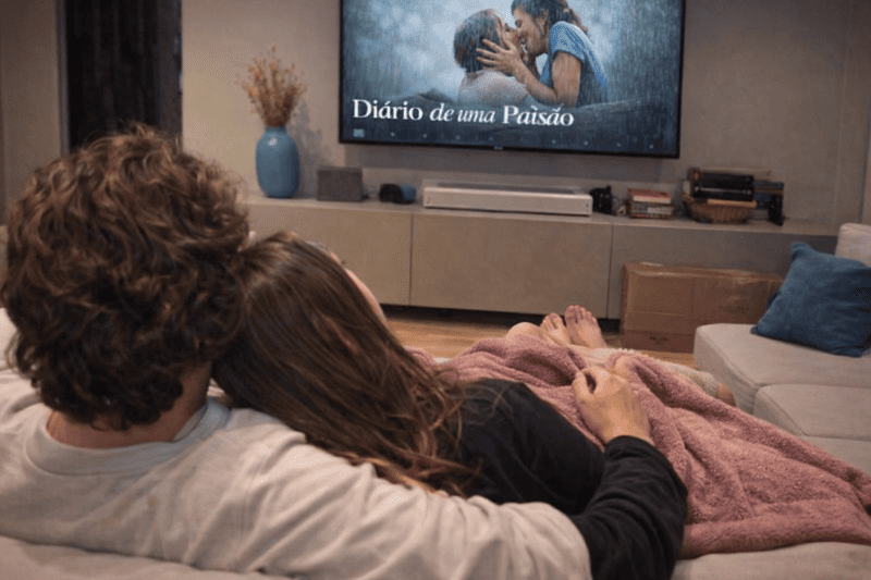 15 Filmes românticos para assistir no Valentine’s Day 2 Casal no sofá assistindo filmes românticos para assistir no Valentine’s Day em um clima aconchegante